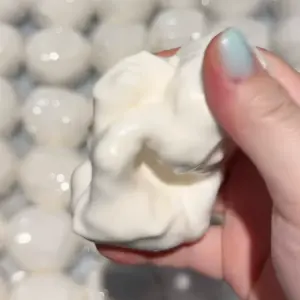 Minimalist white squishy ball held in hand