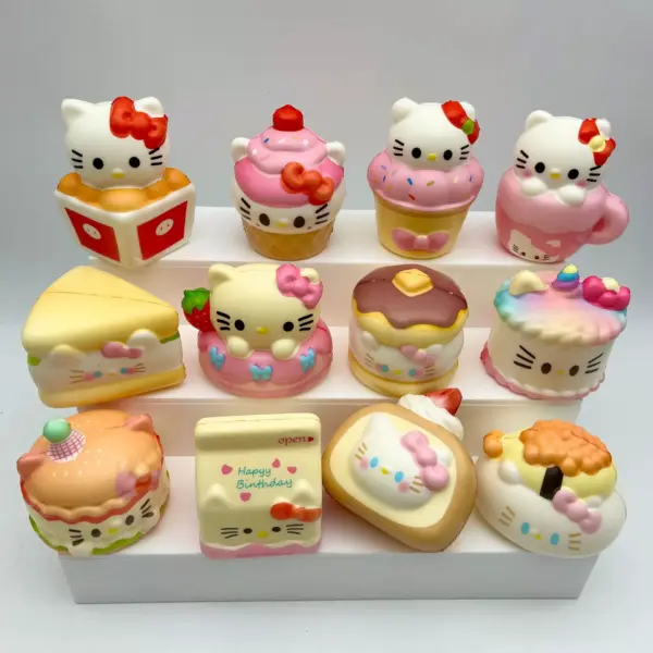 White cat head with red bow, black whiskers, black oval eyes, and yellow oval nose among pastel dessert figures