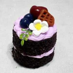 Close-up of piped cream swirls and rosettes on a miniature cake