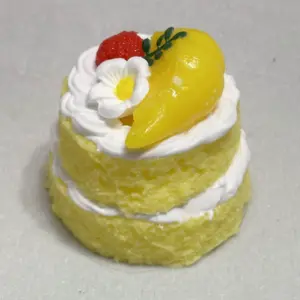 White flowers with yellow centers and green leaf sprigs on a mini cake